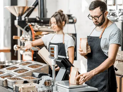 Man and woman filling coffee bags