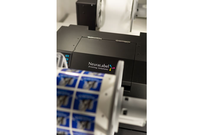 NeuraLabel Sprint desktop printer with a roll of labels
